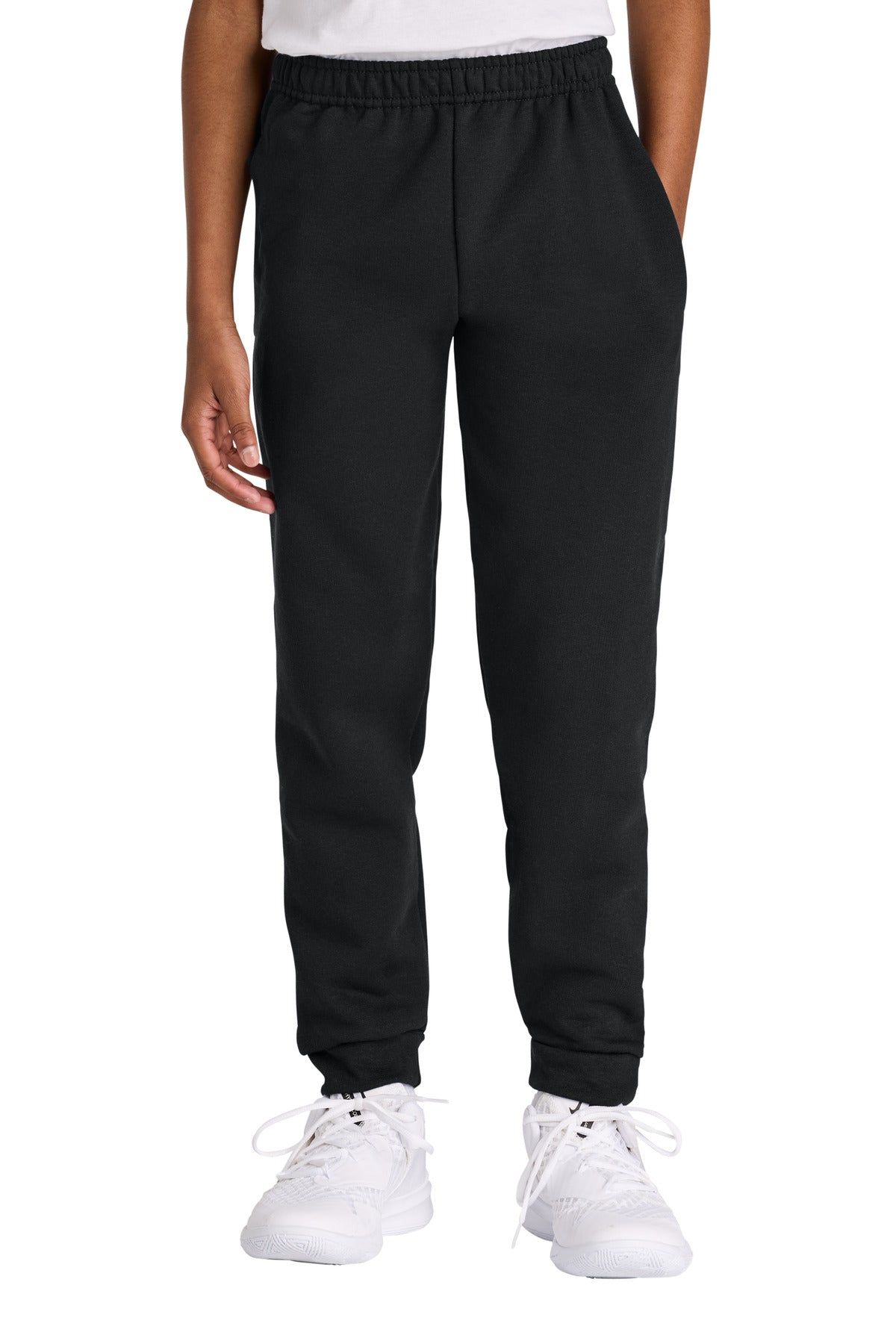 Person wearing black jogger pants and white sneakers on a white background