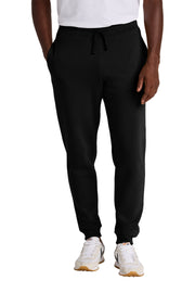 Person wearing black sweatpants and white sneakers on a white background