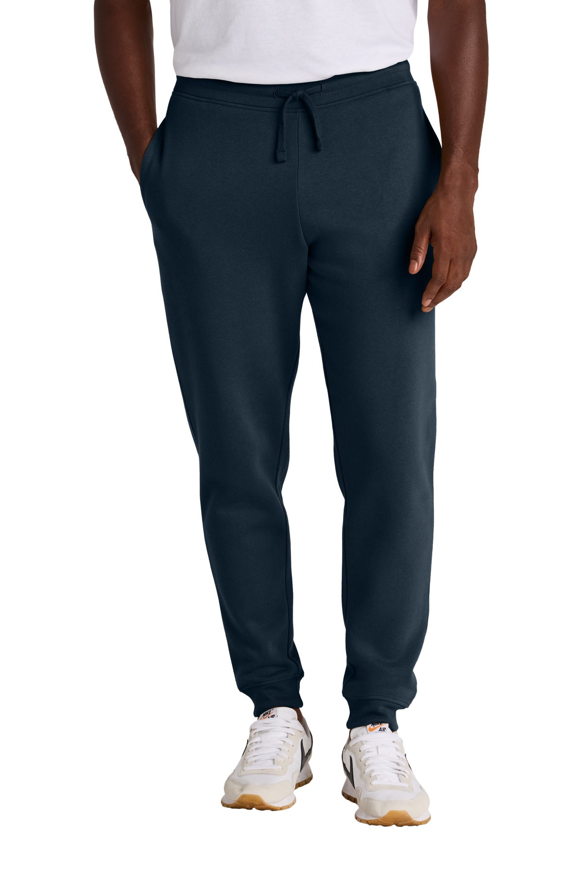 Person wearing navy jogger pants on a white background
