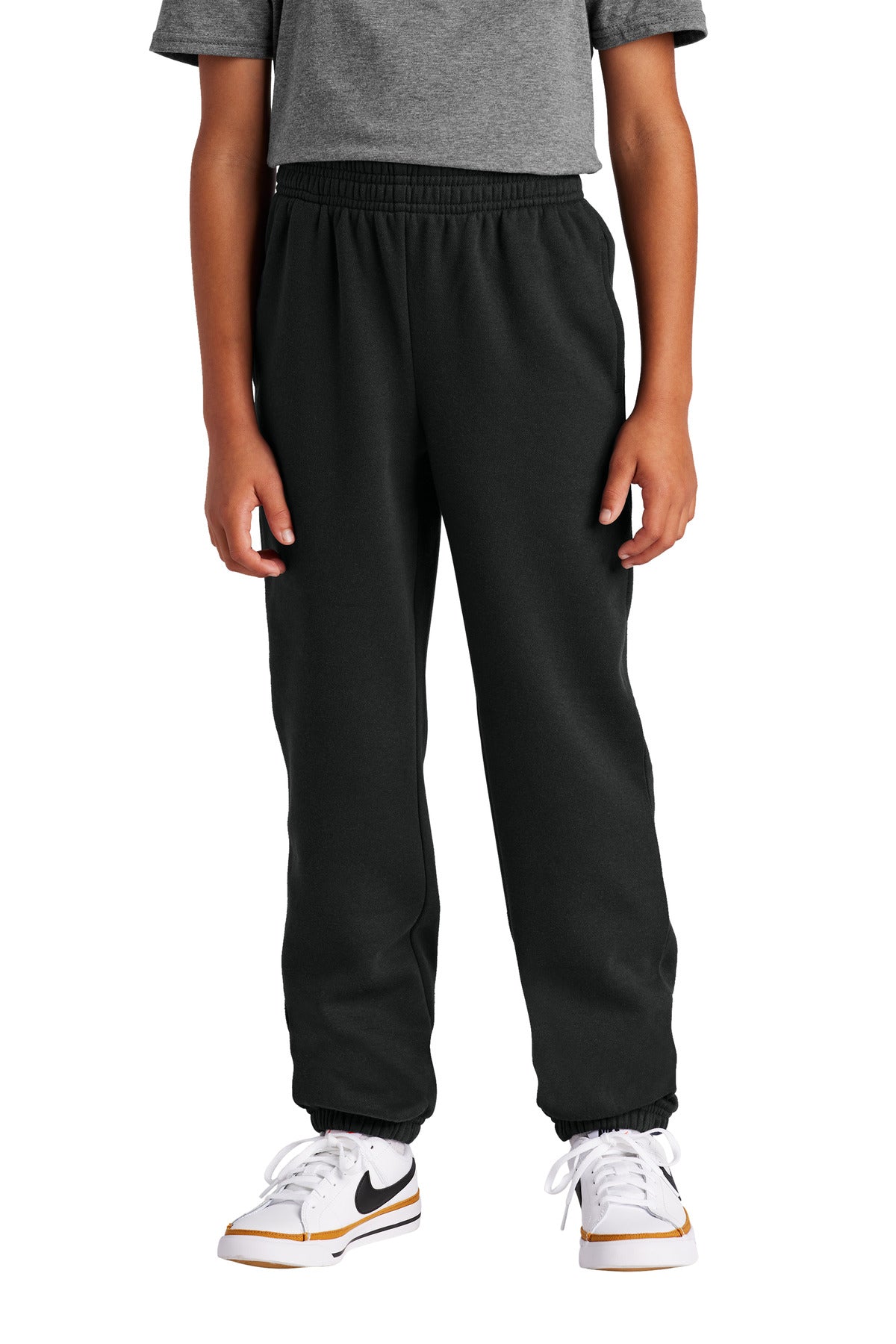 Person wearing black pants and white sneakers with a brand logo on a white background