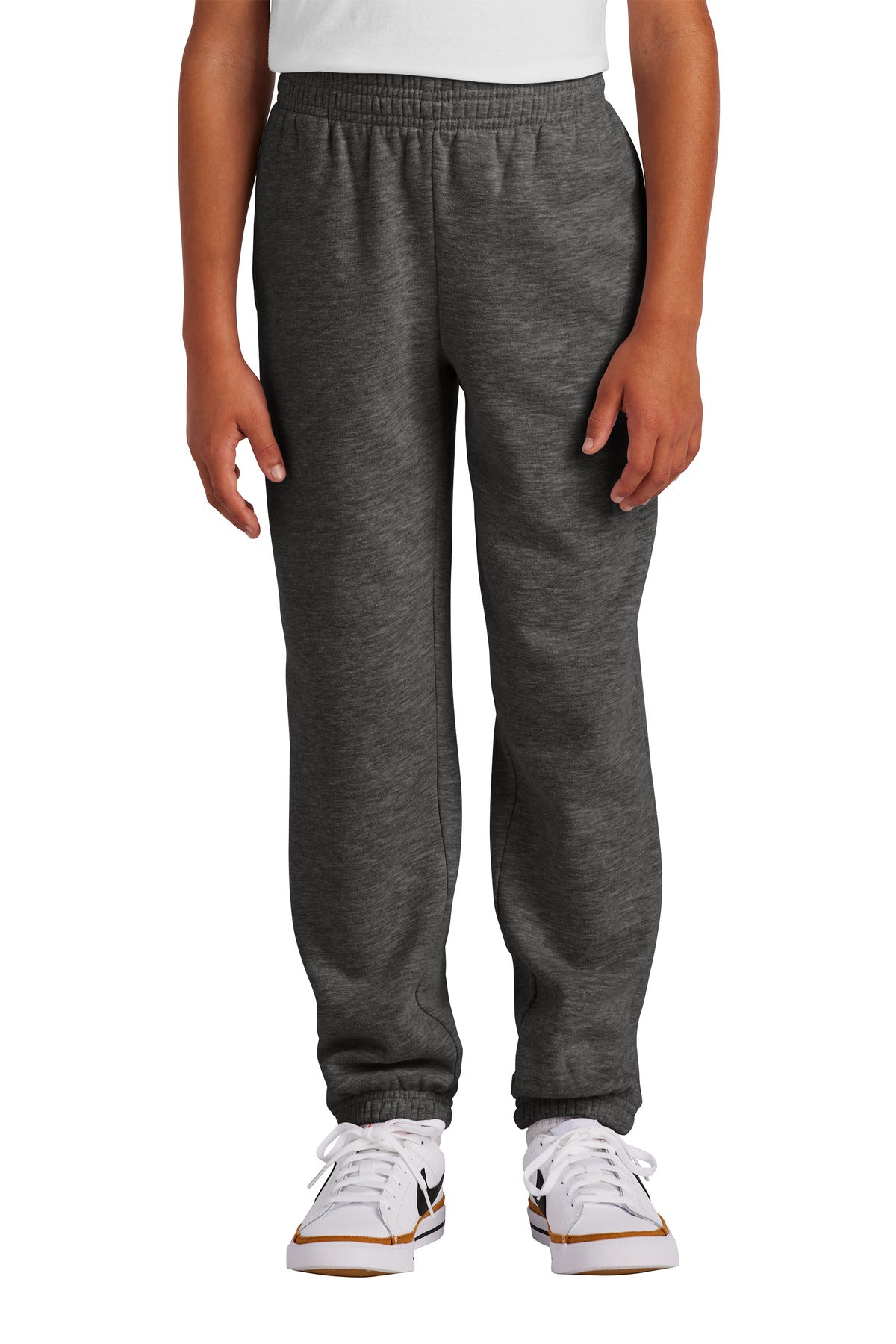 Person wearing gray sweatpants and white sneakers on a white background