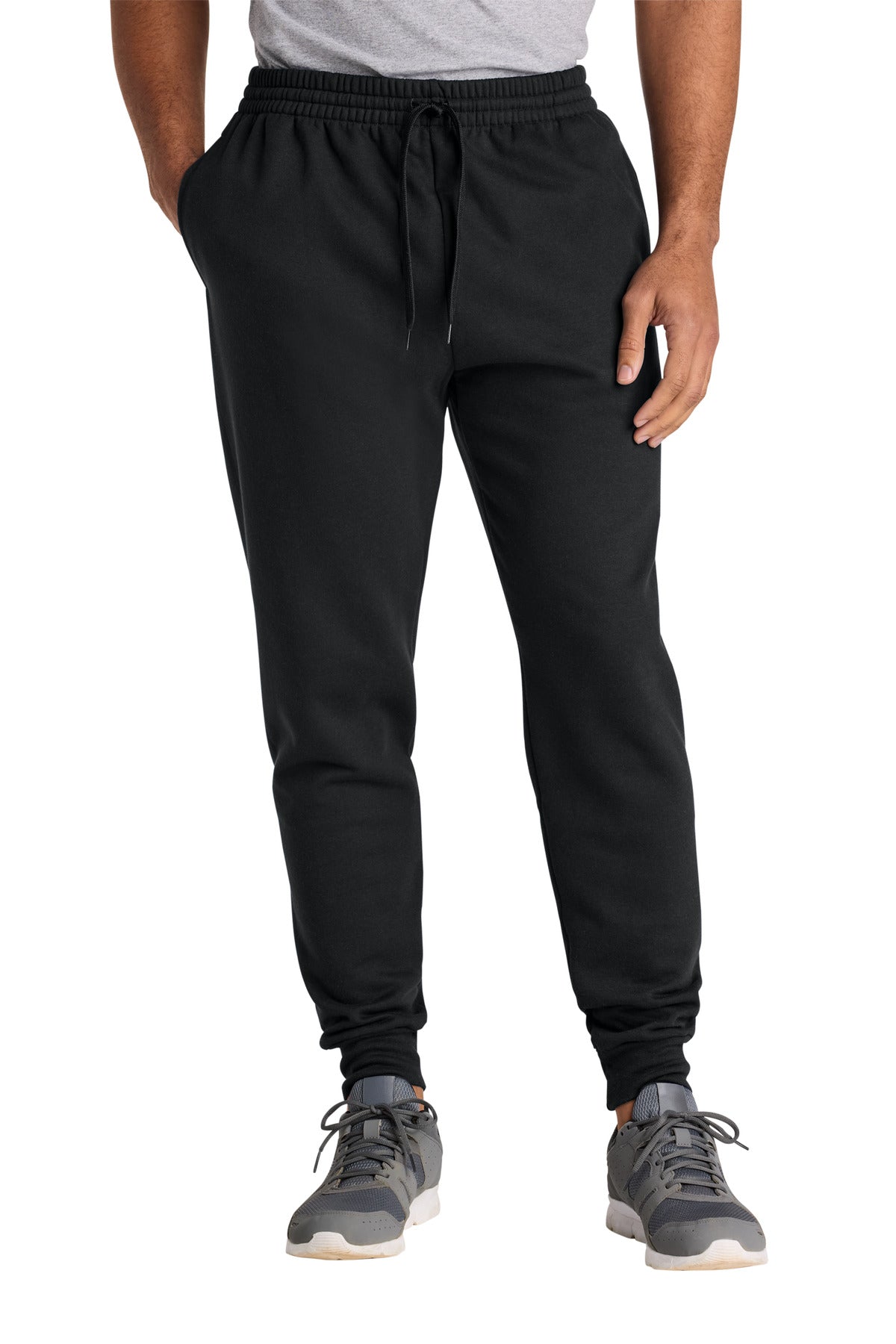 Person wearing black jogger pants on a white background