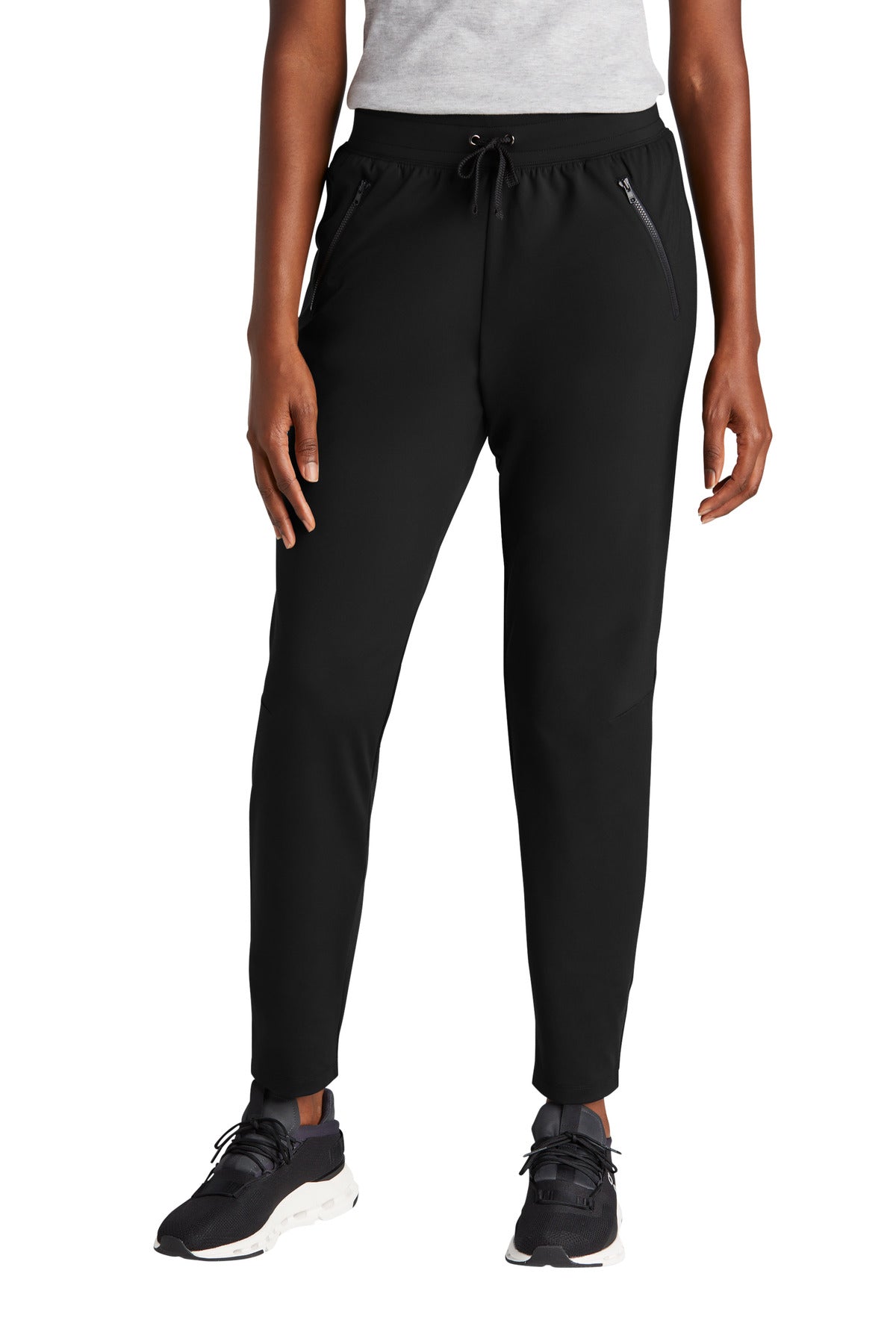 Person wearing black jogger pants on a white background