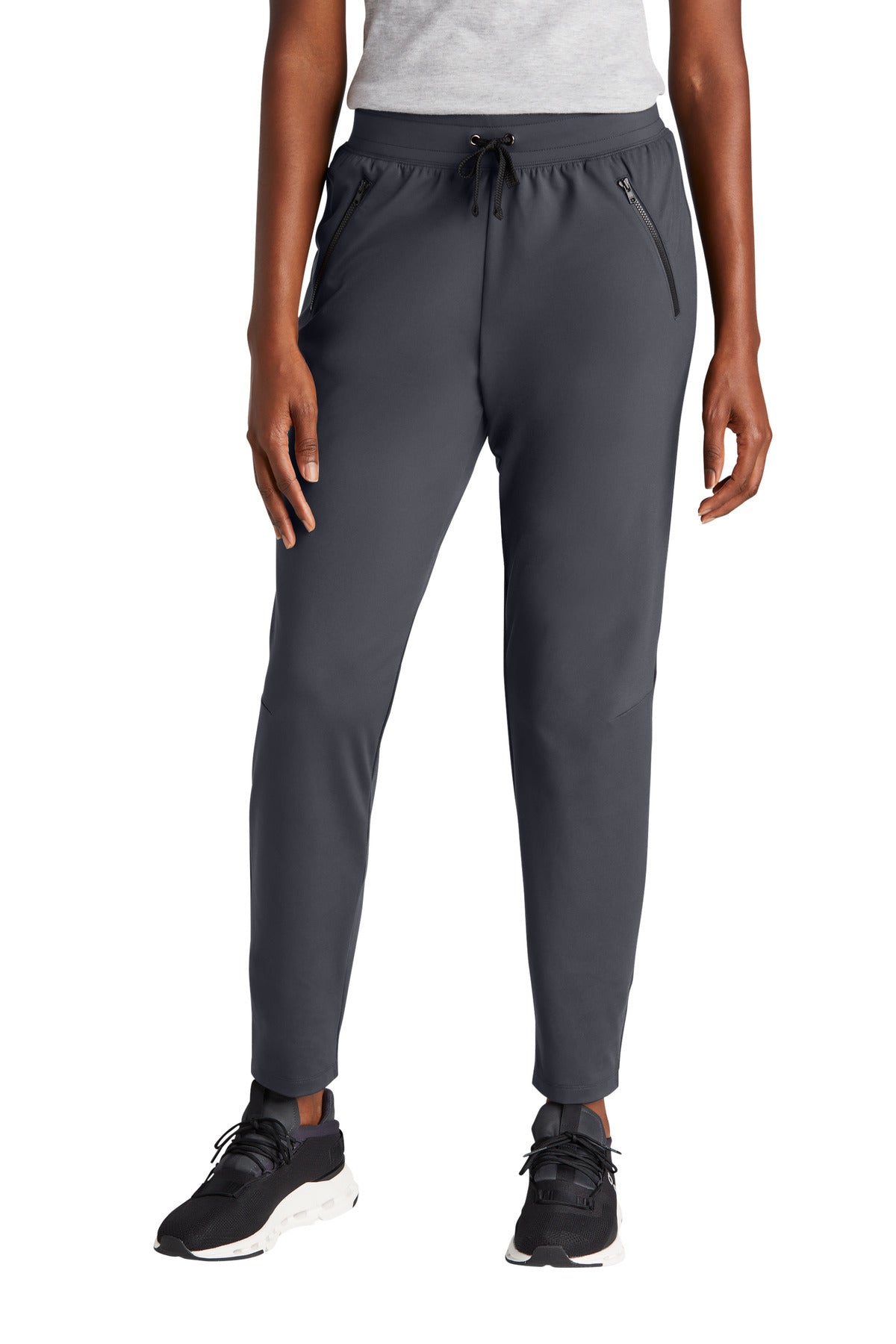 Person wearing gray jogger pants on a white background
