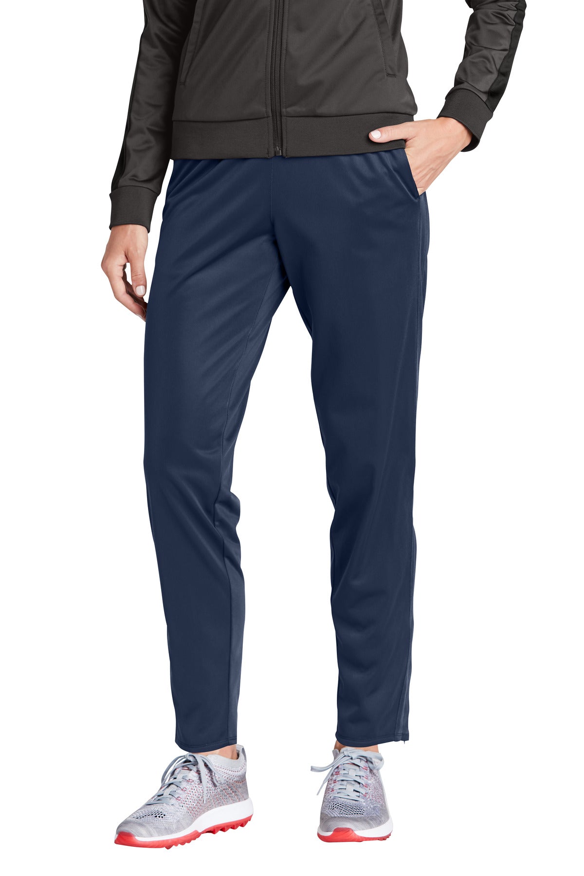 Person wearing navy pants with a black jacket on a white background