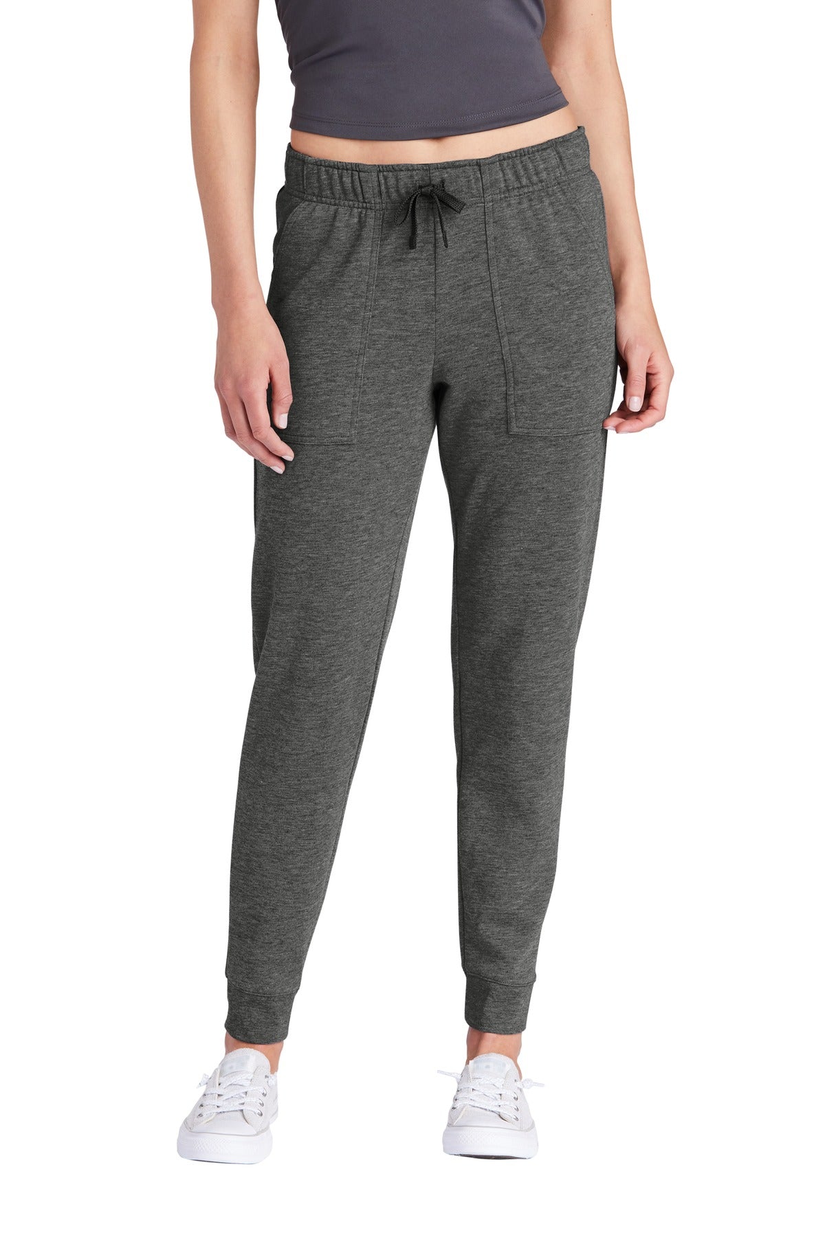 Person wearing gray jogger pants on a white background
