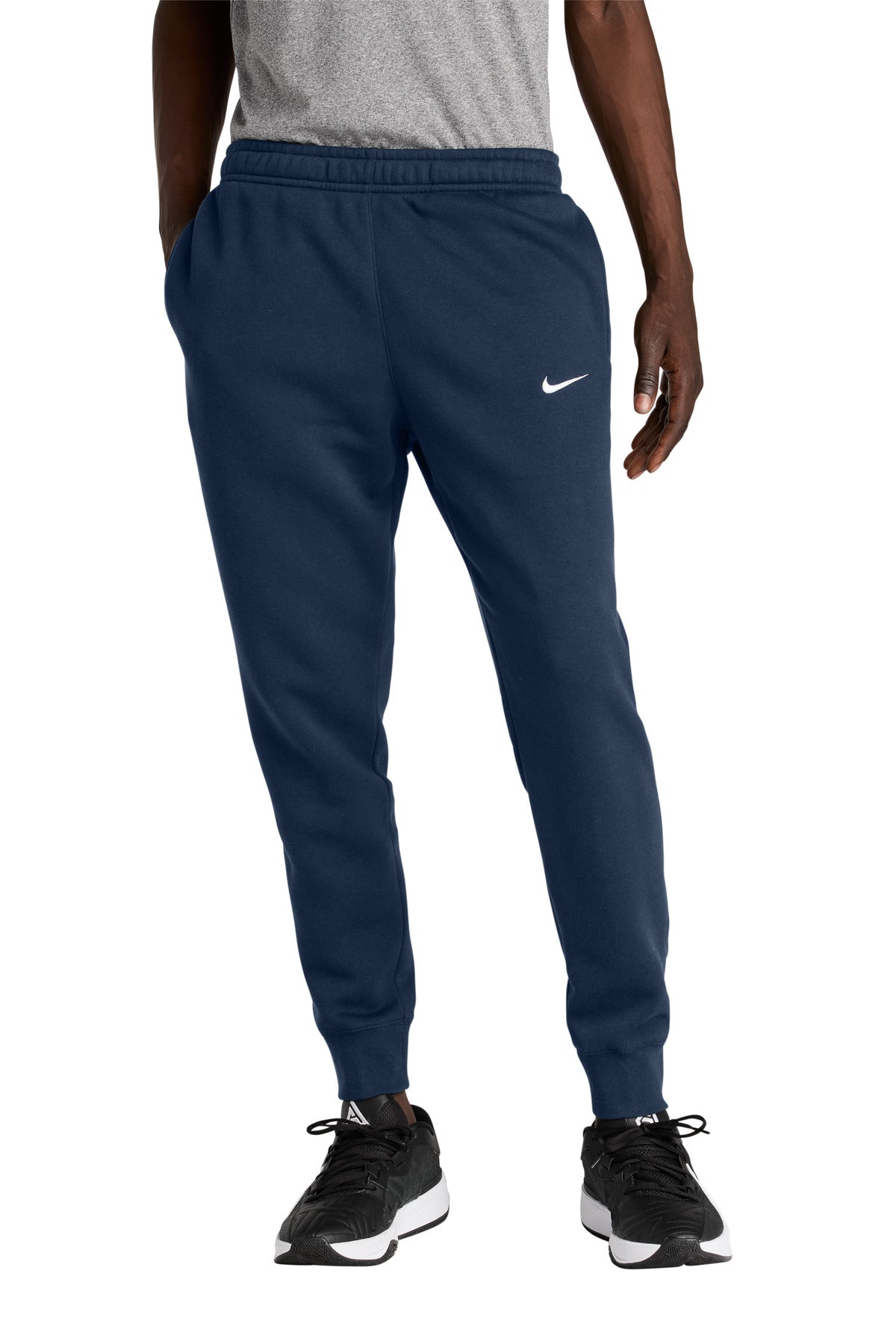 Person wearing navy blue Nike tracksuit pants on a white background