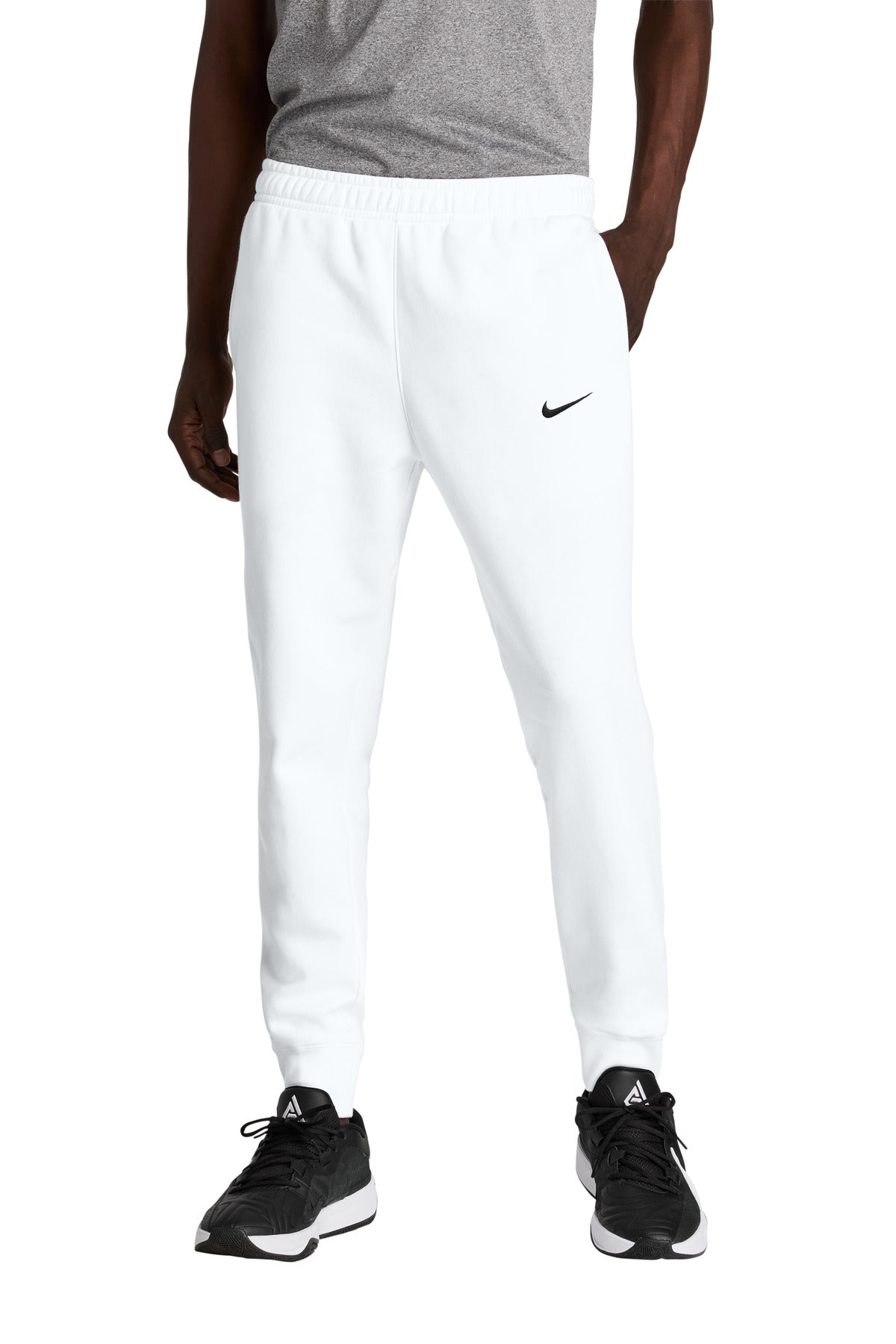 Person wearing white Nike sweatpants on a white background