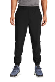 Person wearing black jogger pants on a white background