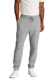 Person wearing gray jogger pants and white sneakers on a white background