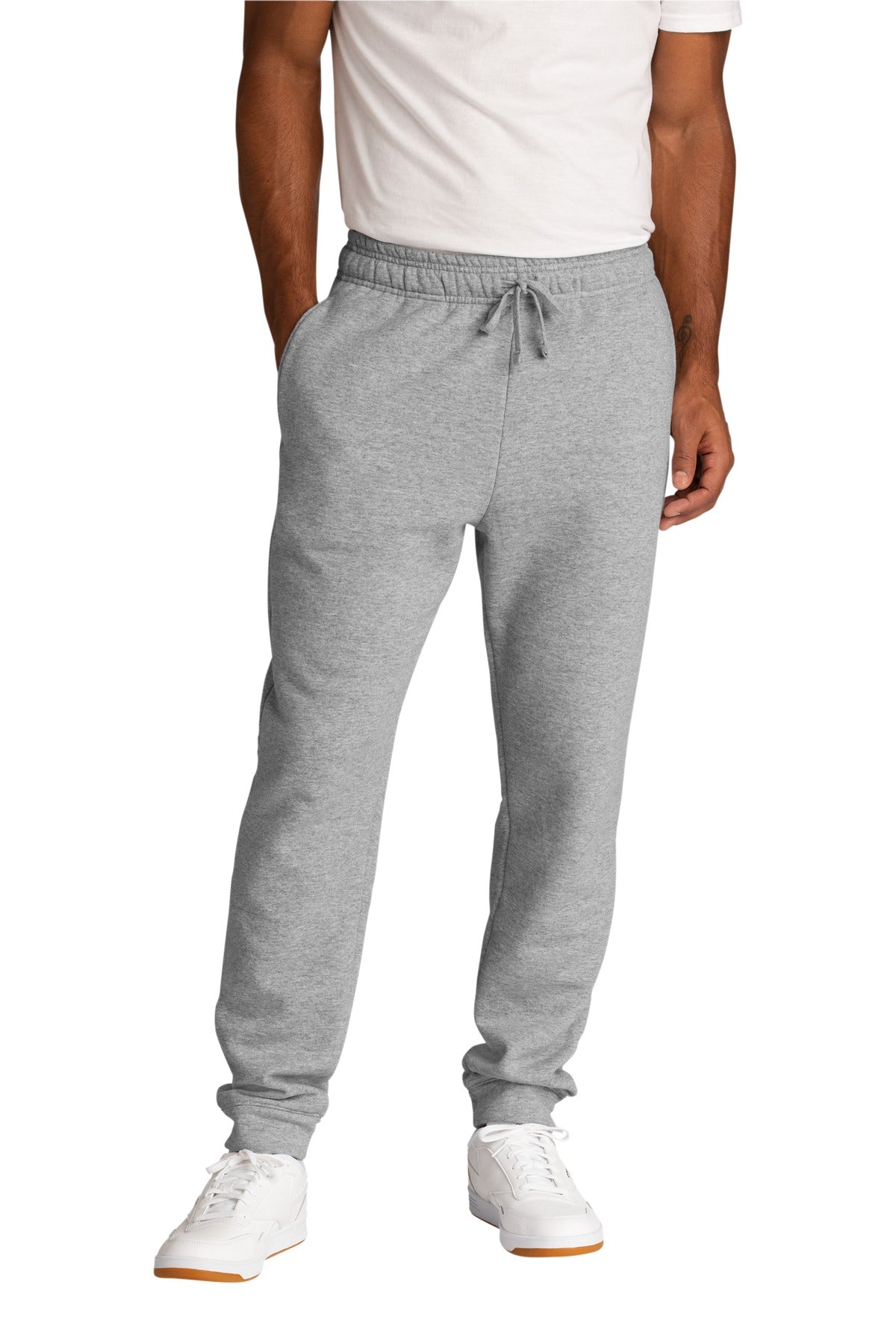 Person wearing gray jogger pants and white sneakers on a white background