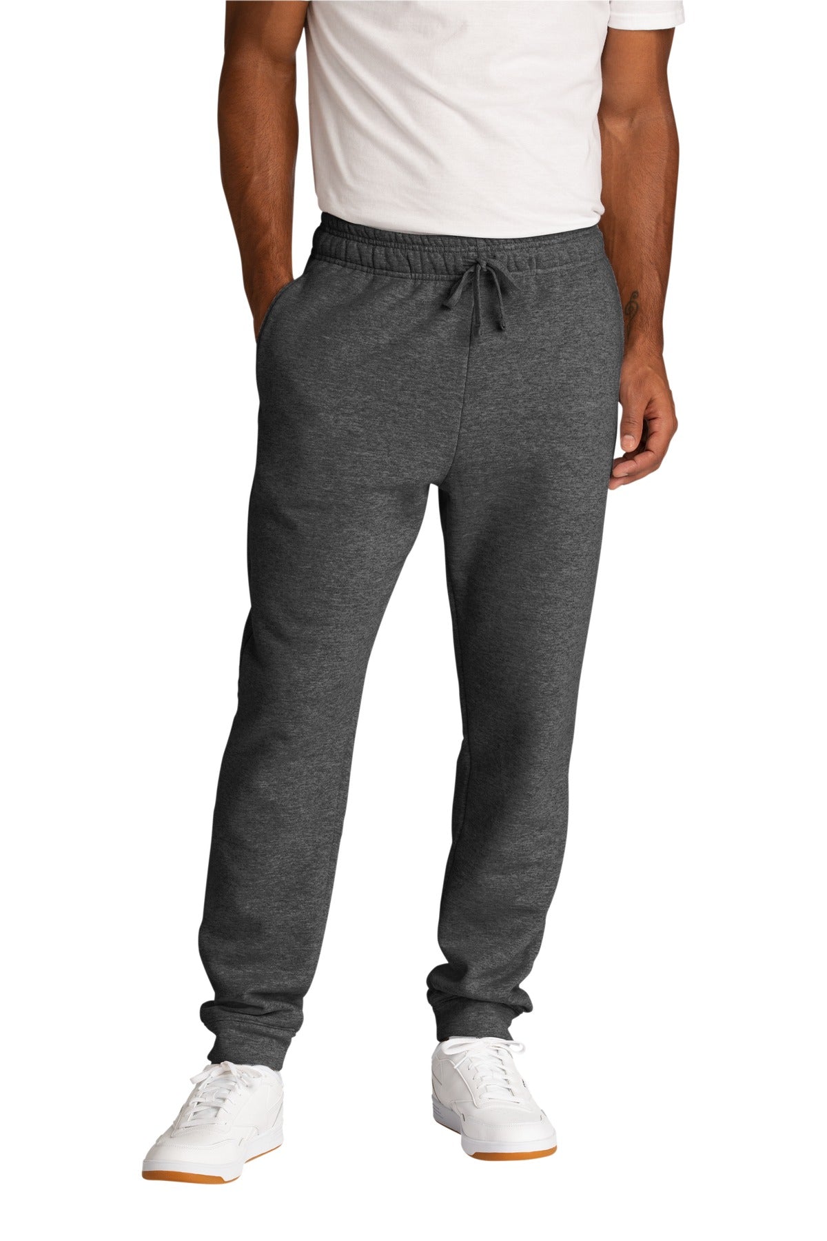 Person wearing gray jogger pants and white sneakers on a white background