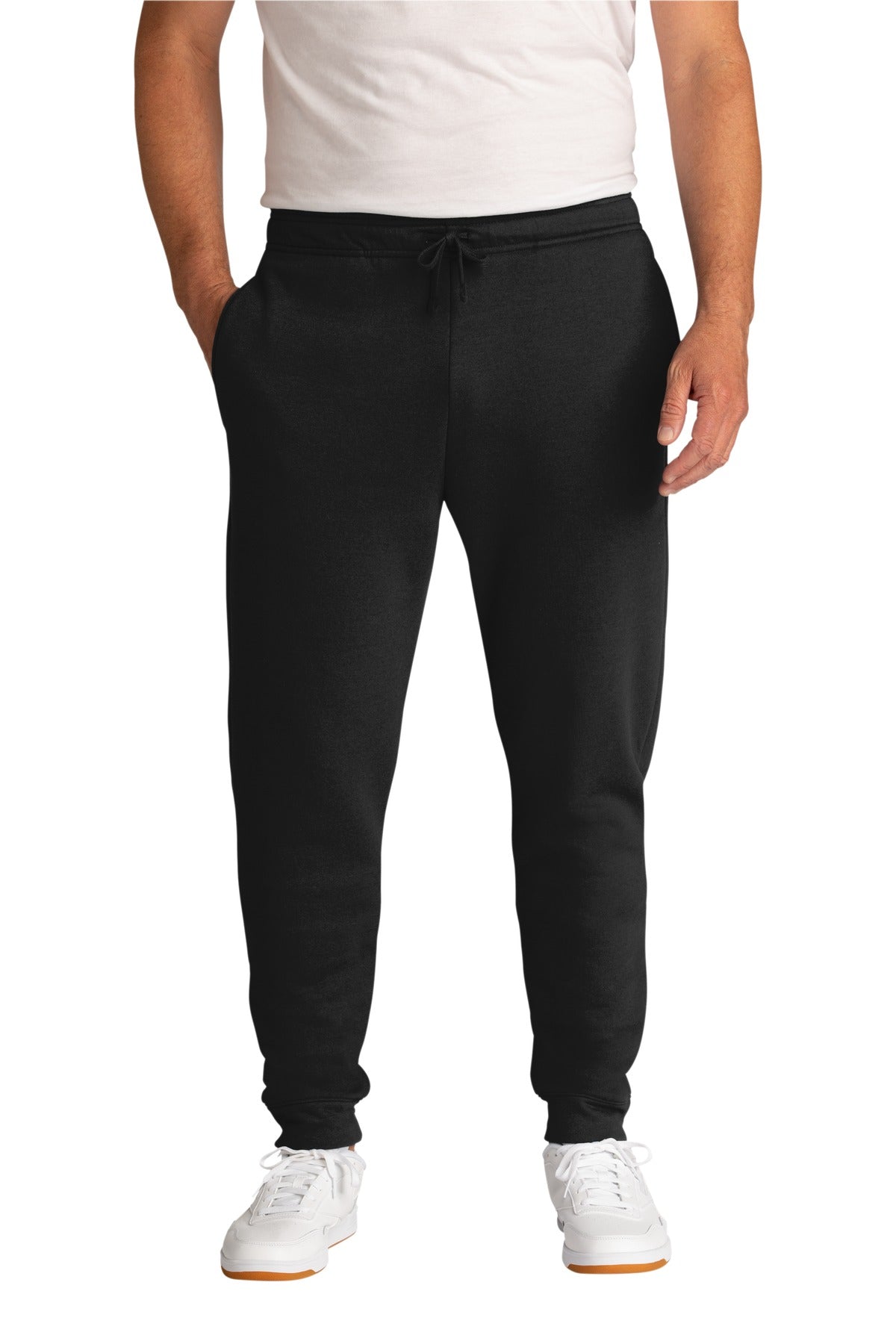 Person wearing black jogger pants and white shoes on a white background