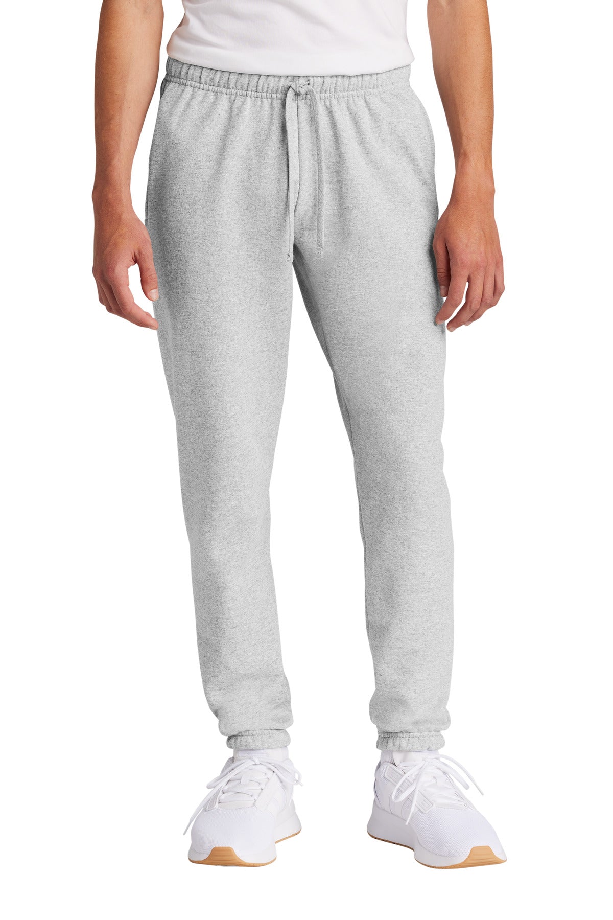Person wearing gray sweatpants and white sneakers on a white background