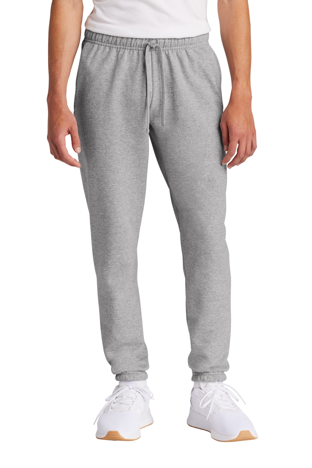 Person wearing gray sweatpants and white sneakers on a white background