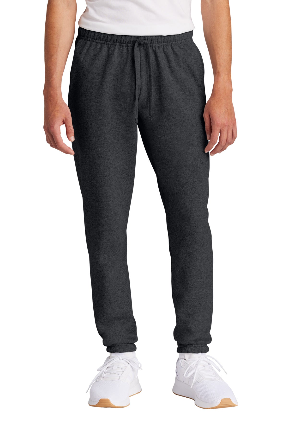 Person wearing dark gray sweatpants and white sneakers on a white background