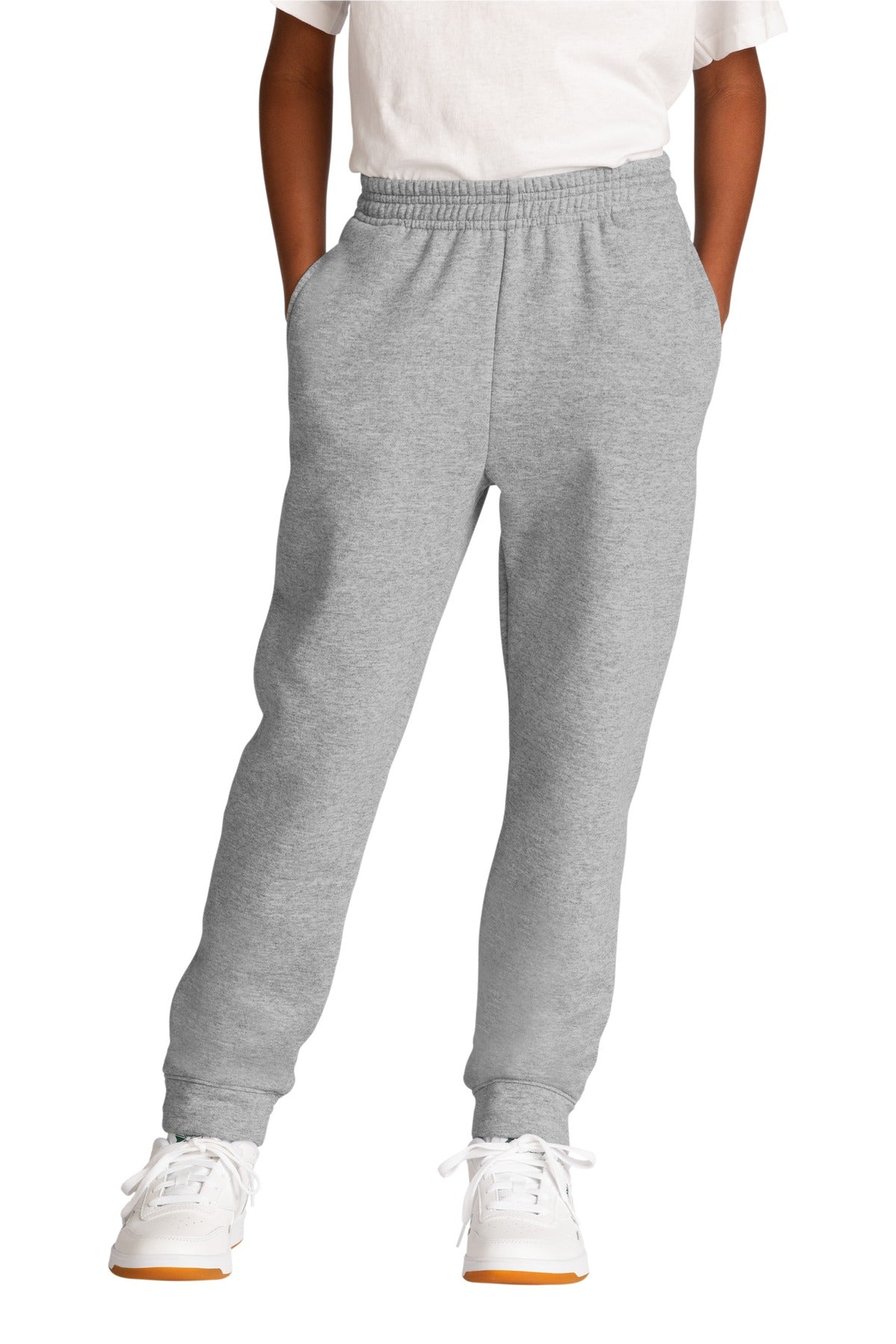 Person wearing gray sweatpants and white sneakers on a white background