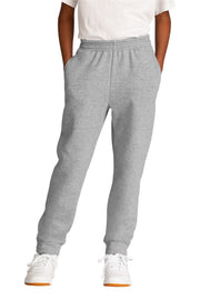 Person wearing gray sweatpants and white sneakers on a white background