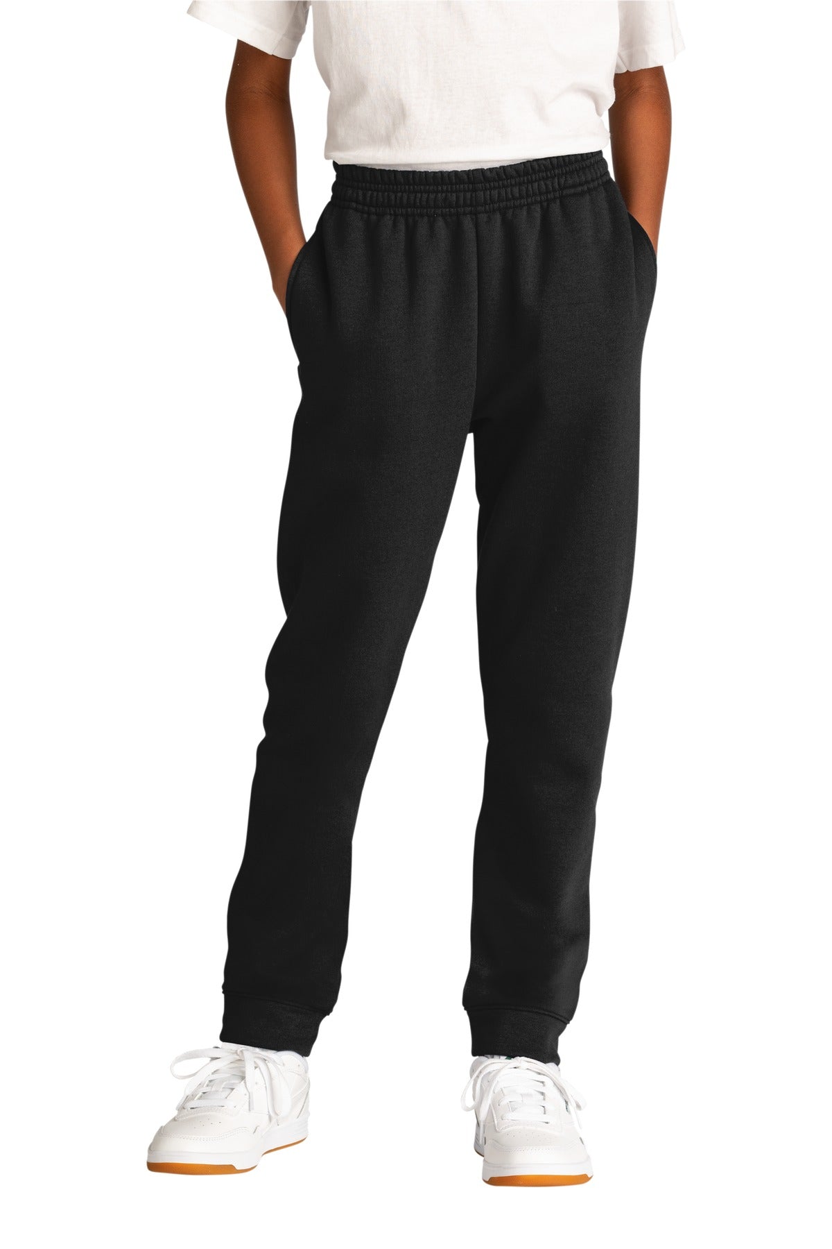 Person wearing black sweatpants and white shoes on a white background