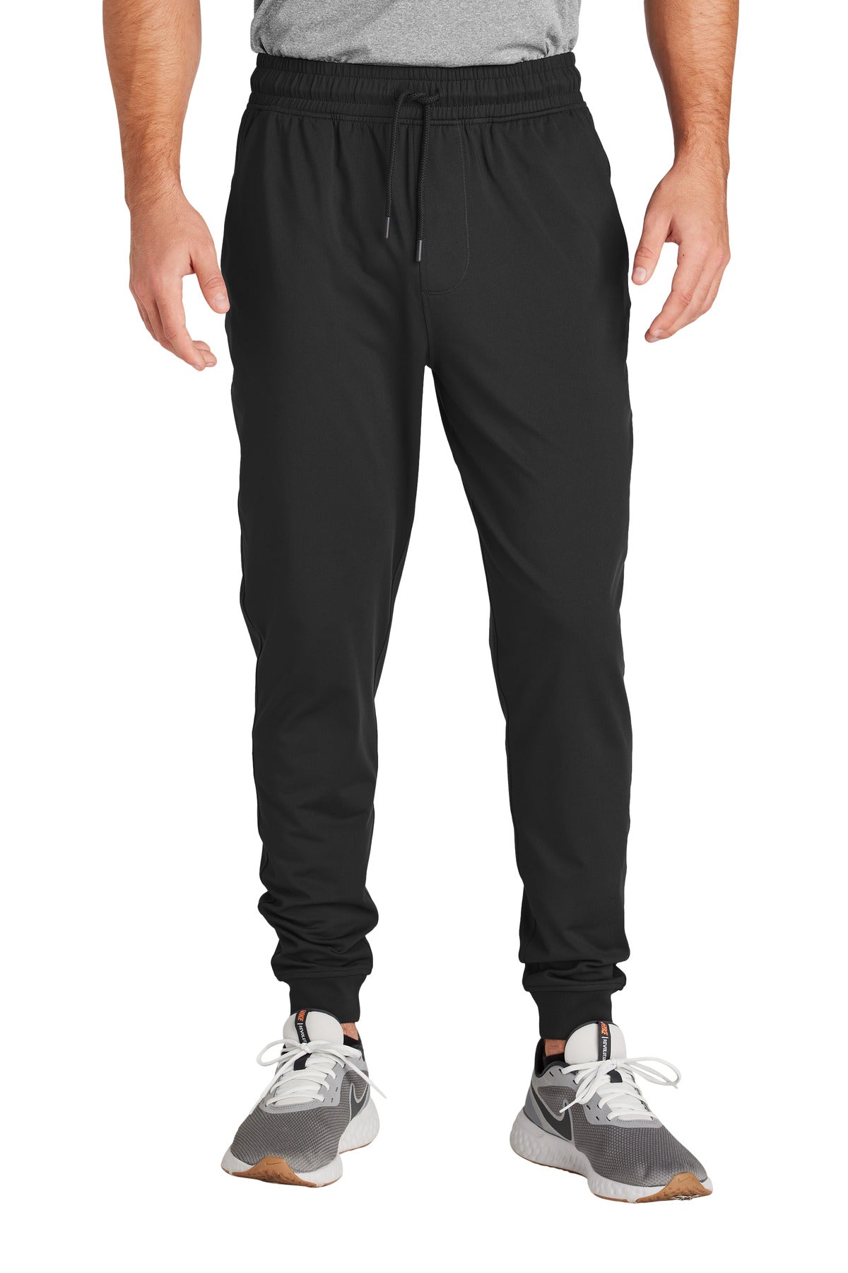 Person wearing black jogger pants on a white background