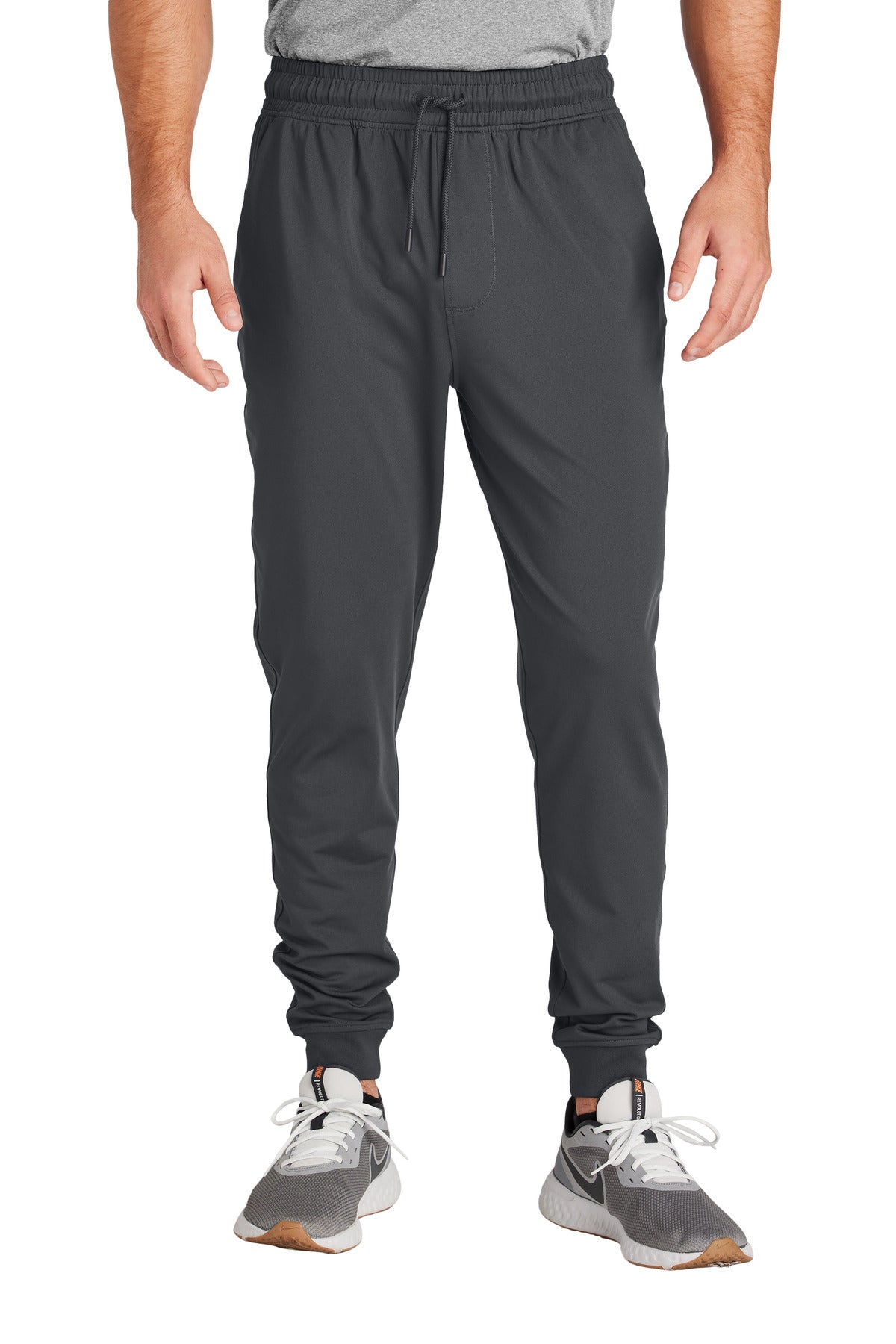 Person wearing gray jogger pants on a white background