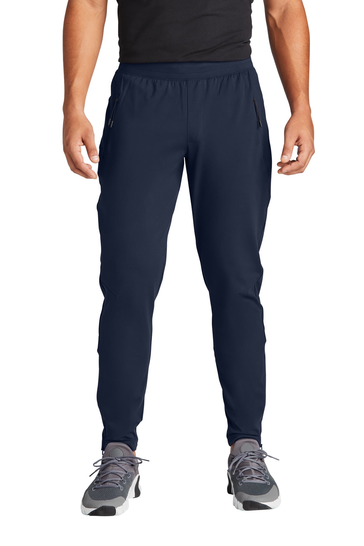 Person wearing navy athletic pants on a white background