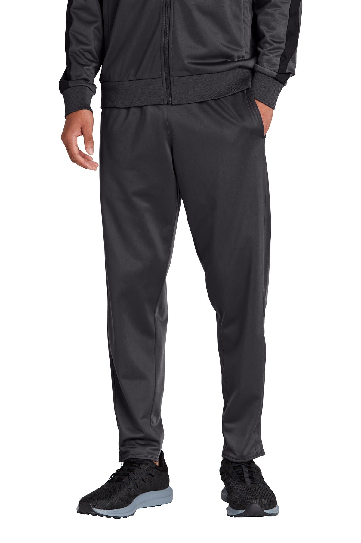 Person wearing a dark gray tracksuit on a white background