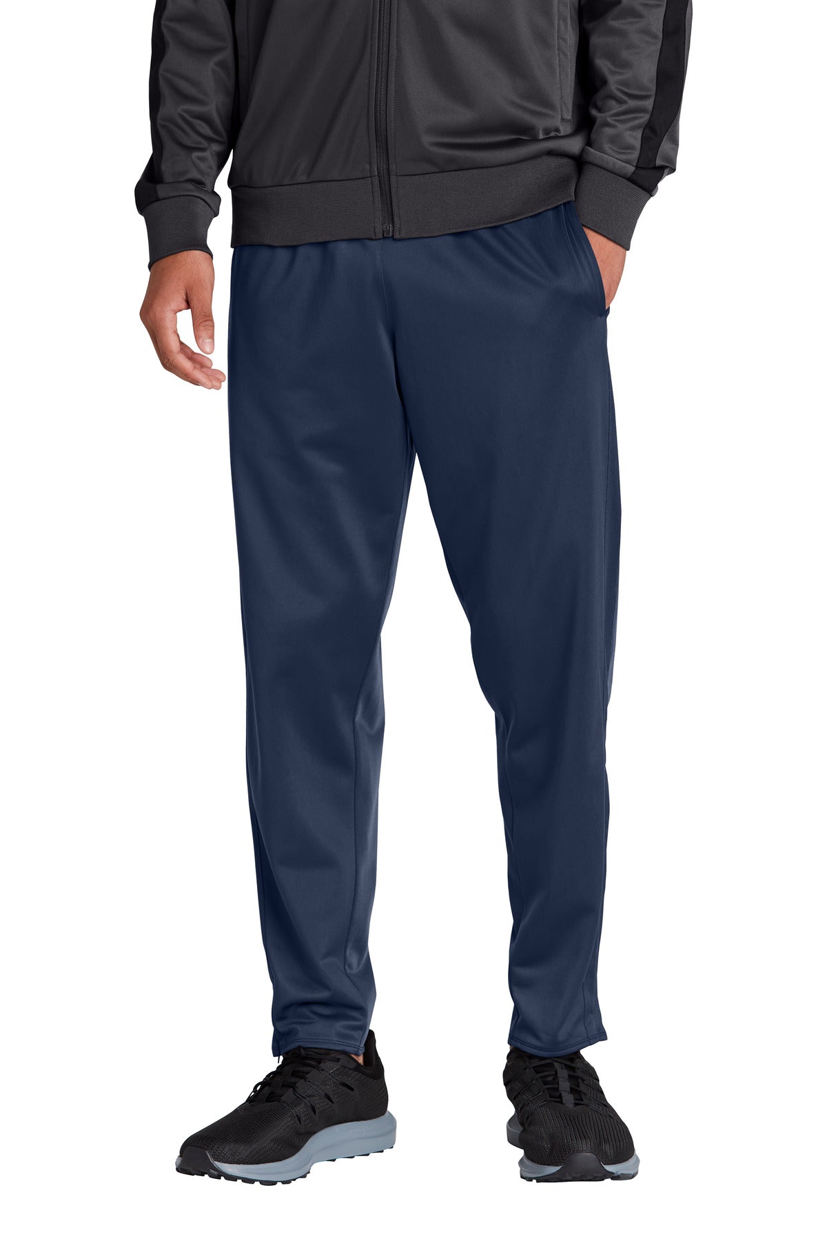 Person wearing navy pants and black jacket on a white background