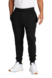 Person wearing black Champion sweatpants and white sneakers on a white background