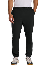 Person wearing black jogger pants on a white background