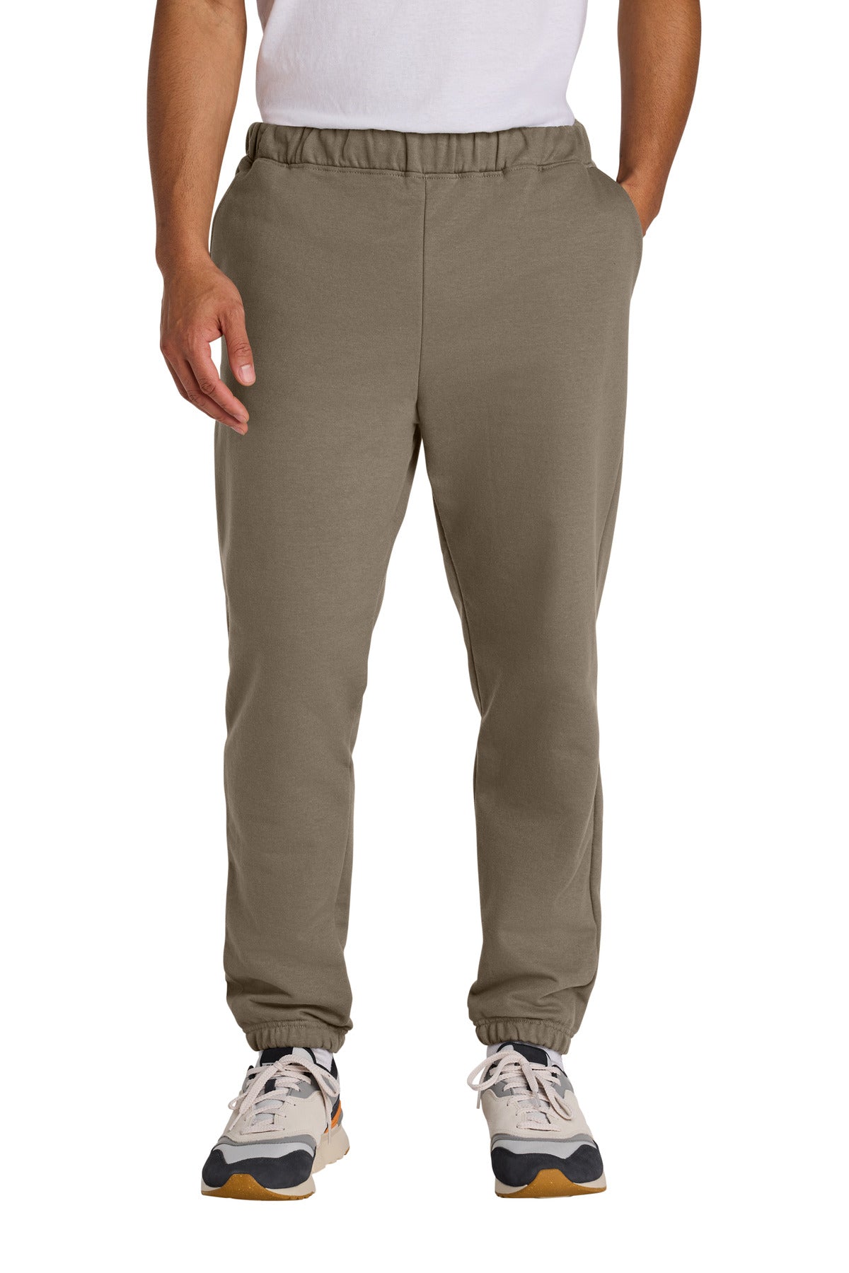 Person wearing beige jogger pants on a white background