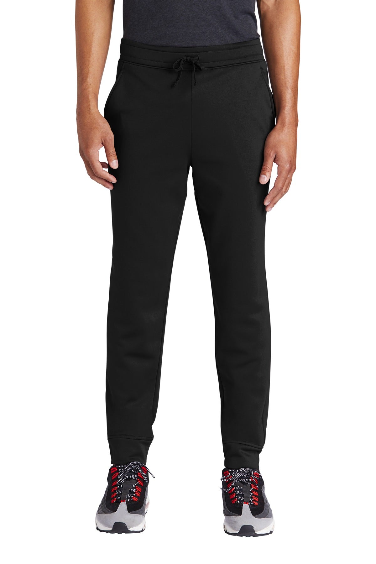Person wearing black jogger pants on a white background