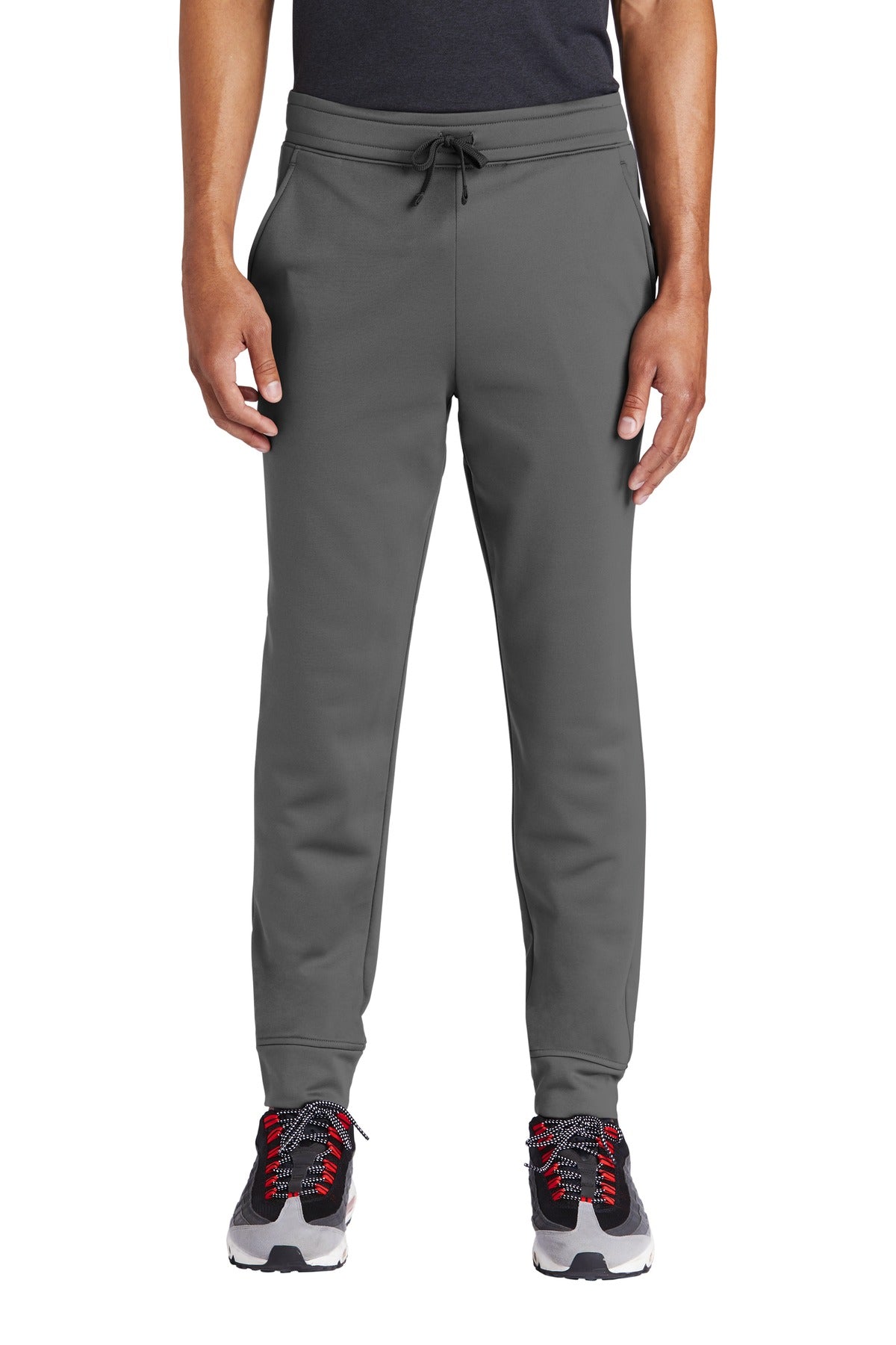 Person wearing gray jogger pants on a white background