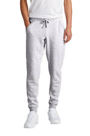 Person wearing gray sweatpants and white sneakers on a white background