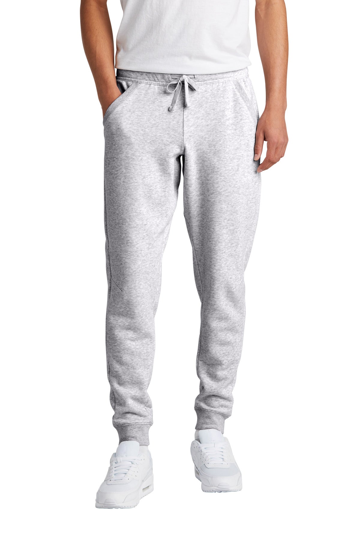 Person wearing gray sweatpants and white sneakers on a white background