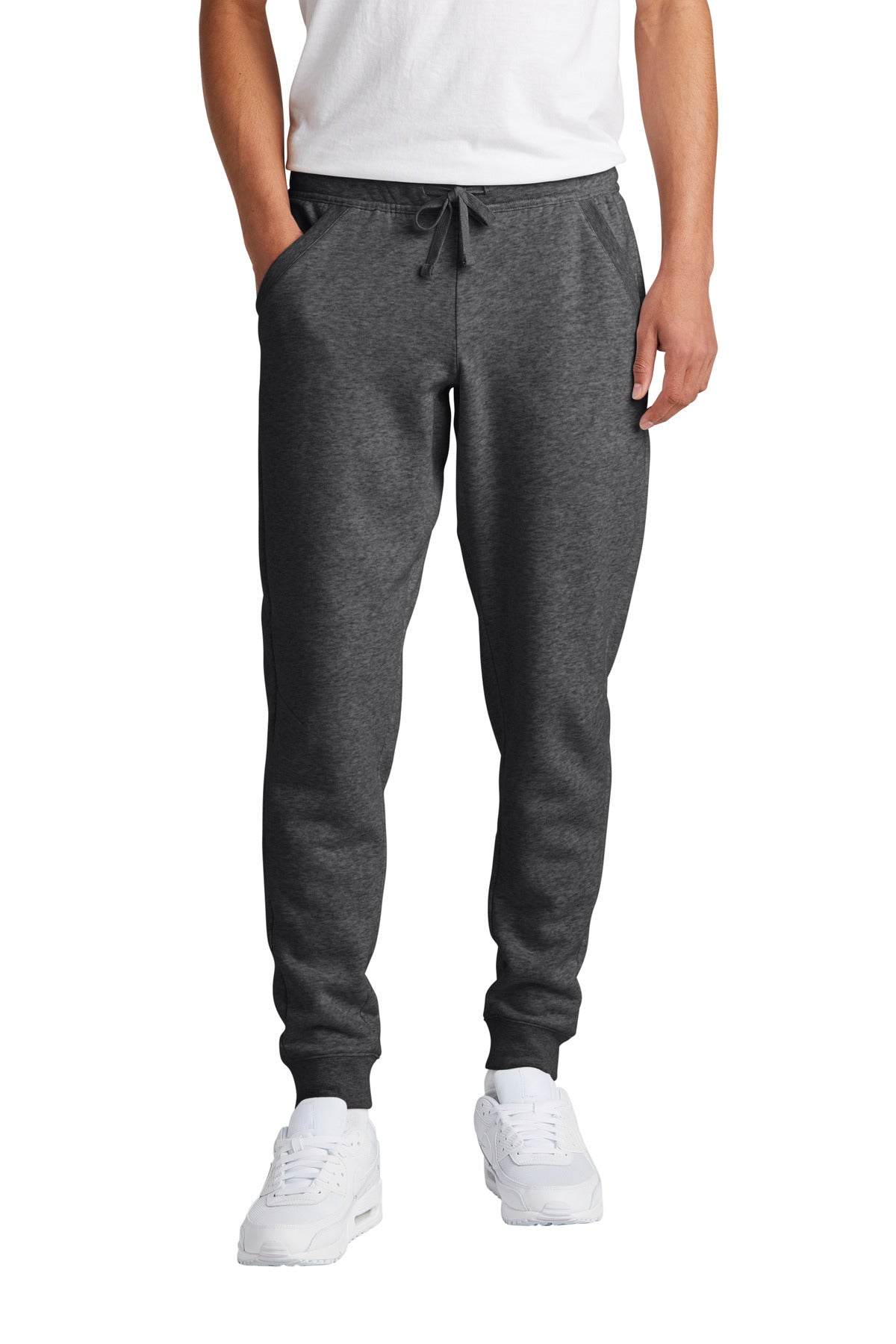 Person wearing gray sweatpants and white shoes on a white background